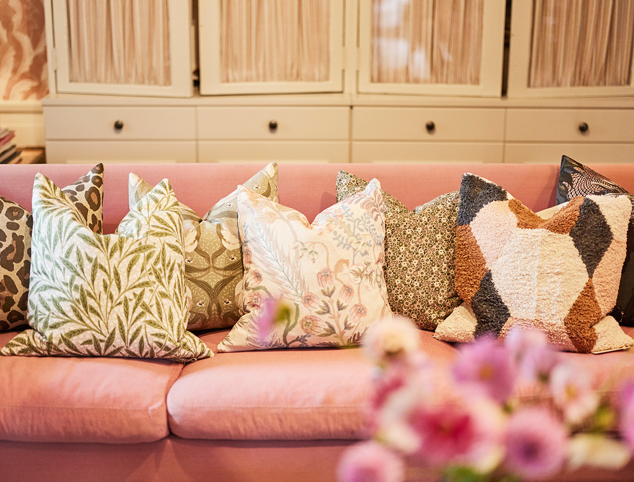 En rosa soffa med kuddar 